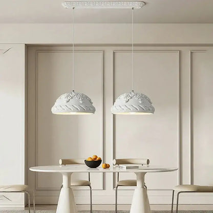 Two elegant french cream style led pendant lights with ornate domes hang above a minimalist dining table decorbites french cream