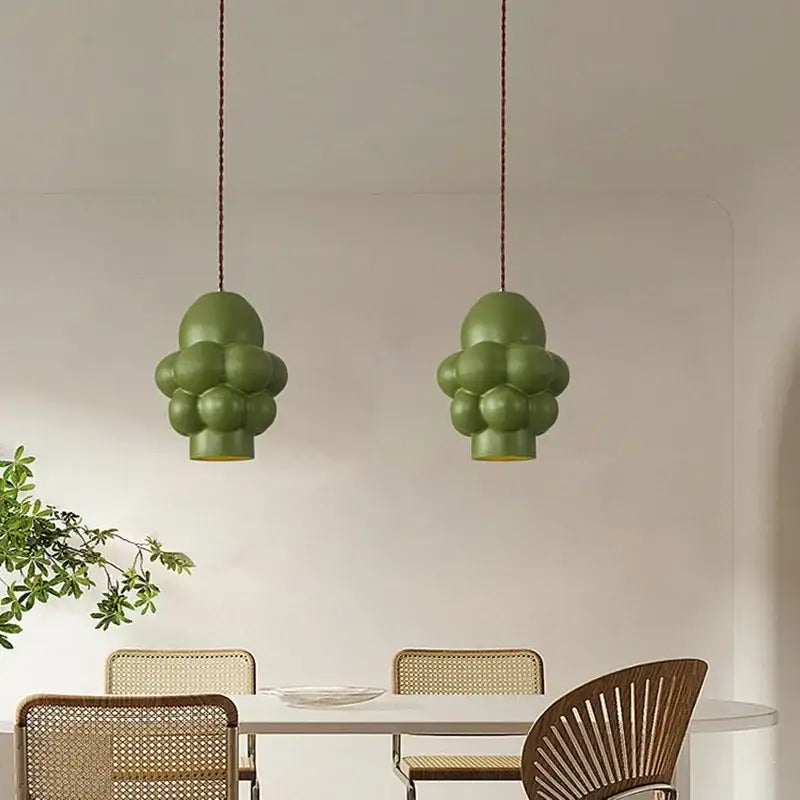 Two olive green bubble-shaped creamy wind led pendant lights hang from ceiling cords for dining room decorbites french creamy decor