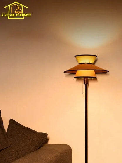 A sleek black floor lamp with a tiered amber shade featuring decorbites french design for living room decor