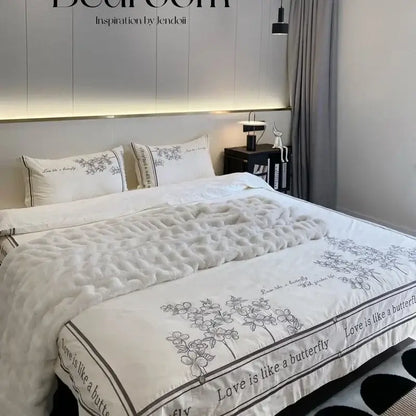 White quilted comforter with delicate black floral embroidery and love is like a butterfly border in french embroidered cotton bedding set