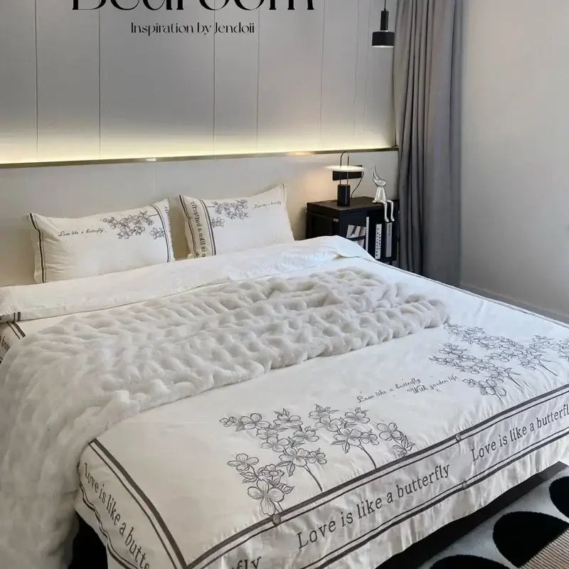 White quilted comforter with delicate black floral embroidery and love is like a butterfly border in french embroidered cotton bedding set