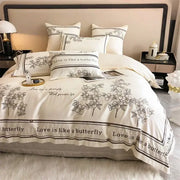 Cream-colored french embroidered cotton bedding set with black floral decor and love is like a butterfly borders