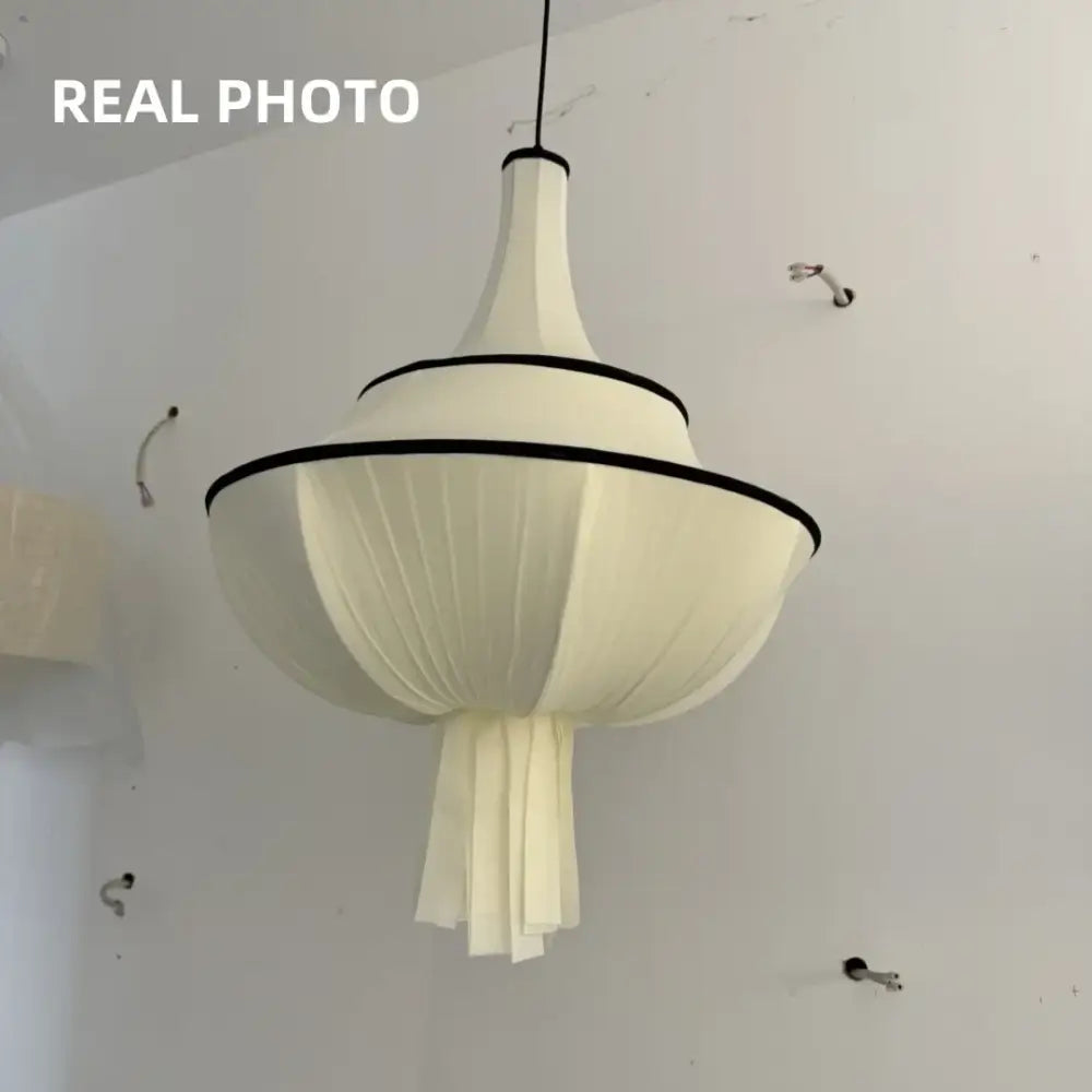 A modern off-white fabric decorbites creamy e27 foyer chandelier with black trim and tiered pleated design for bedroom light