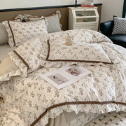 Cream-colored bedding set with delicate brown ruffled trim and lace detailing from decorbites french floral collection