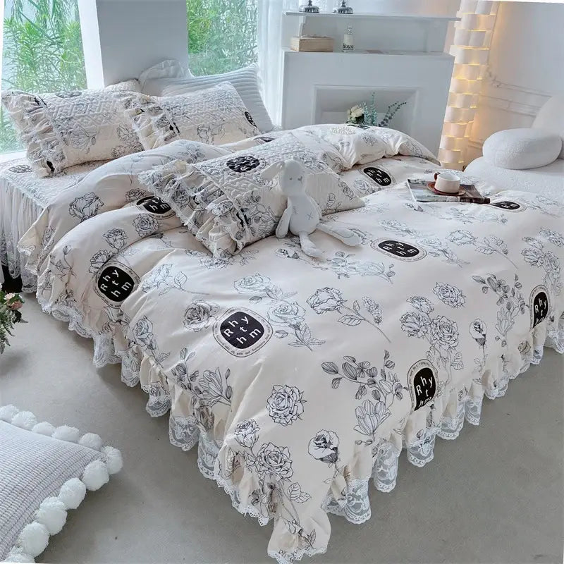 Cream-colored decorbites french floral print bedding set with black floral embroidery lace ruffles and circular rhythm logos
