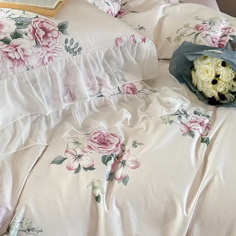 A cream bedding set with soft pink and white floral prints and ruffled edges from decorbites french flowers lace collection