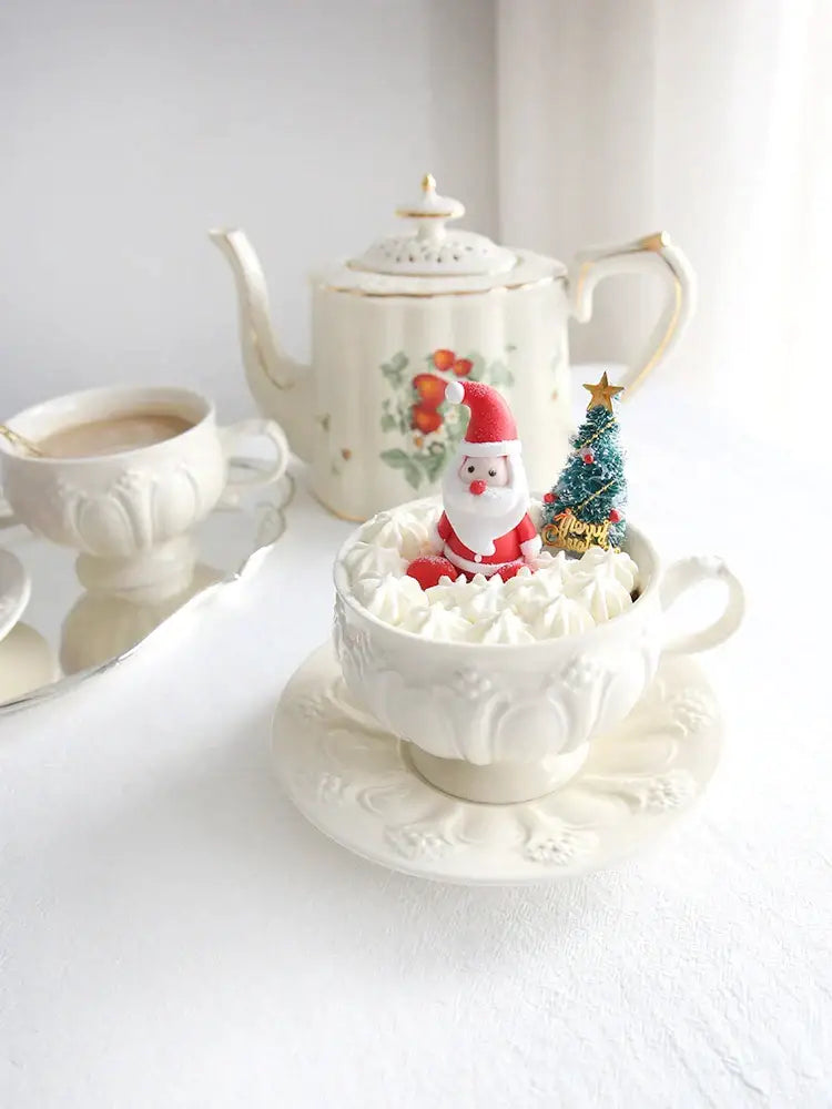 A festive white french garden cream ceramic tea cup with embossed detailing filled with whipped cream and holiday decorbites french garden accents