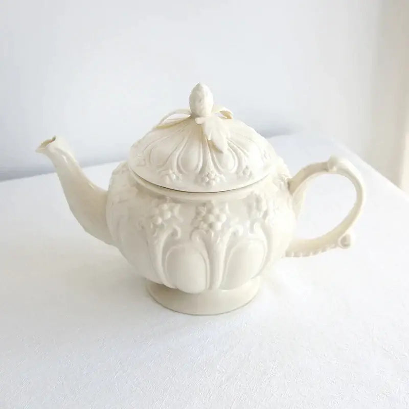 Cream-colored porcelain teapot with intricate floral and fruit embossing in decorbites french garden cream tea cup set