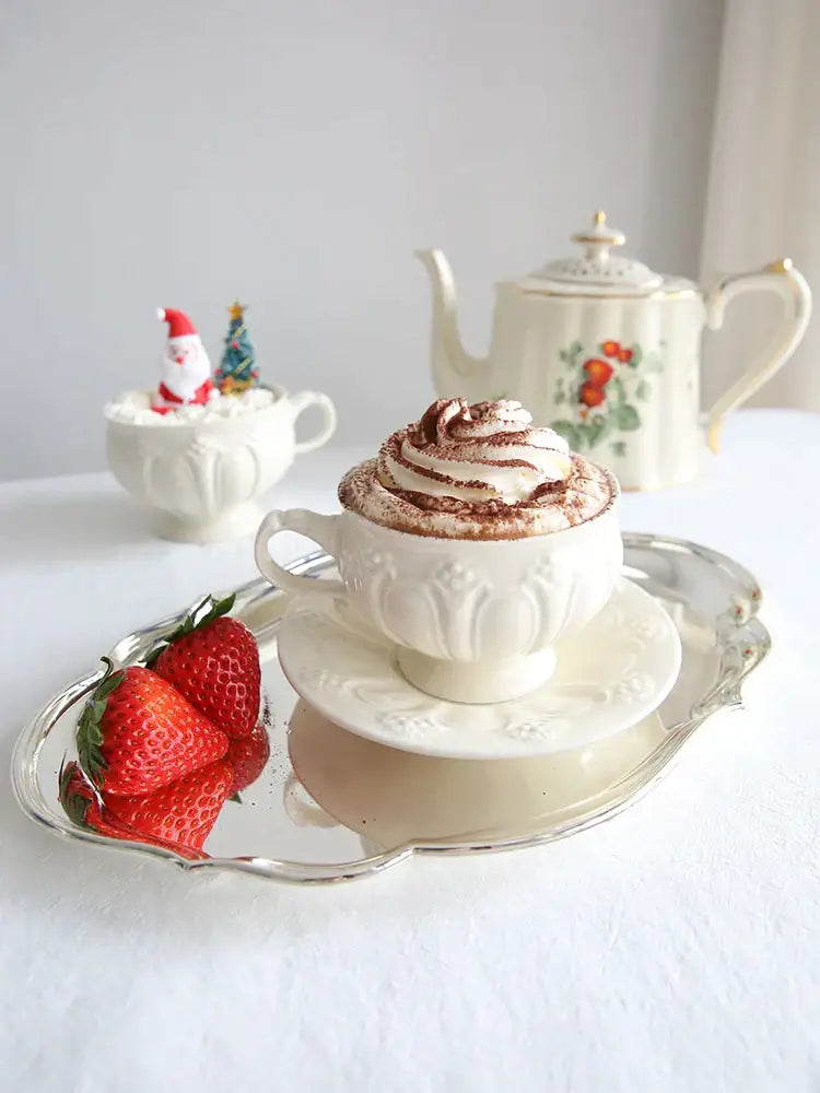 White ceramic tea cup with floral embossing filled with whipped cream and cocoa powder decorbites french garden cream