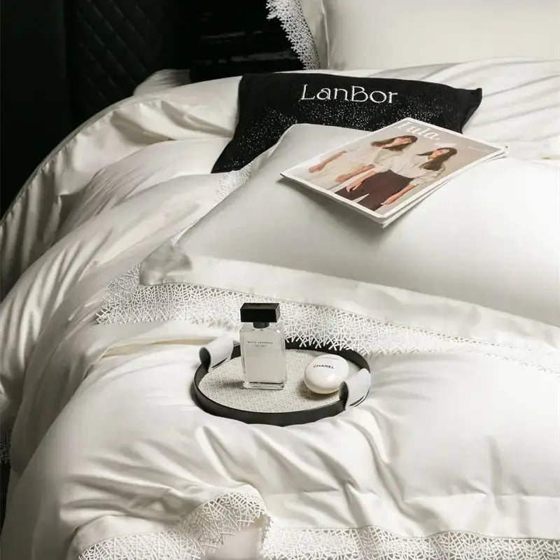 White chanel perfume bottle with black cap on circular tray complements decorbites french lace edge white bedding set