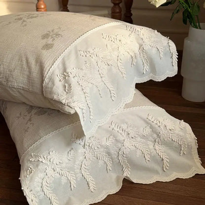 Cream-colored cotton pillowcases with delicate white floral embroidery and scalloped edges in french lace flowers bedding set