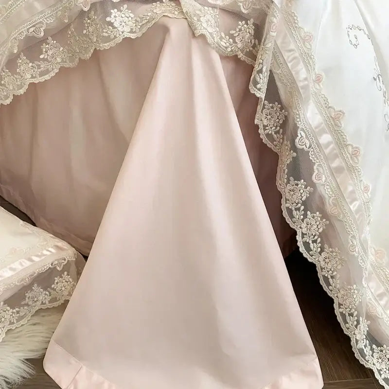 A soft blush pink satin bed canopy with delicate white lace trim and floral embroidery from decorbites french lace bedding set