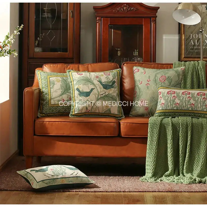 Brown leather sofa with green patterned decorbites french linen bird and flower pillow cover and matching flax blanket