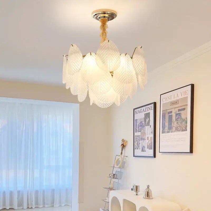 Elegant white glass chandelier with leaf-shaped textured shades and gold-toned fixture for french luxury cream living room decorbites