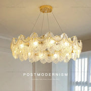 Gold-toned decorbites glass chandelier with intricate crystal lace detailing and dangling teardrop crystals for dining room use