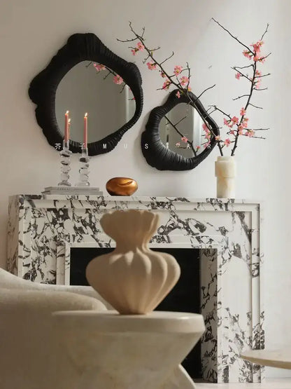 Cream-colored sculptural vase with ribbed texture on white stone pedestal complements decorbites french luxury mirror