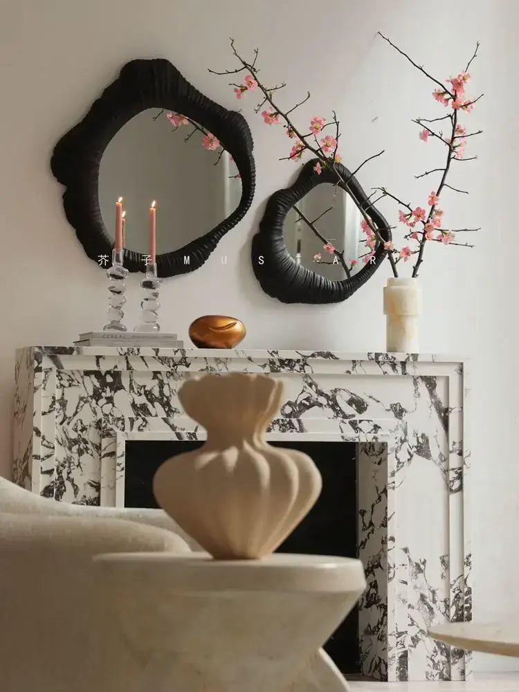 Cream-colored sculptural vase with ribbed texture on white stone pedestal complements decorbites french luxury mirror