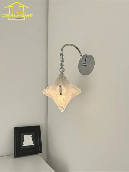 A french medieval bauhaus wall lamp with chrome metal arm and diamond glass shade emitting warm light for living room
