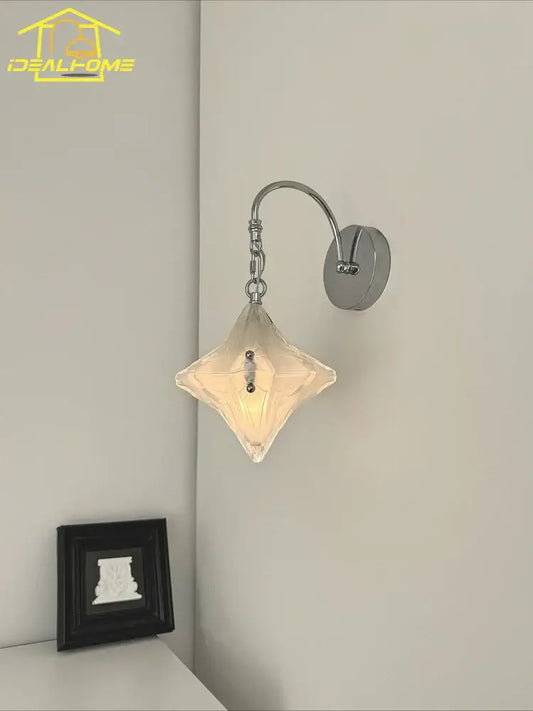 A french medieval bauhaus wall lamp with chrome metal arm and diamond glass shade emitting warm light for living room