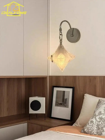 A french medieval bauhaus wall lamp featuring a warm diamond-shaped glass pendant with a chrome curved arm for living room