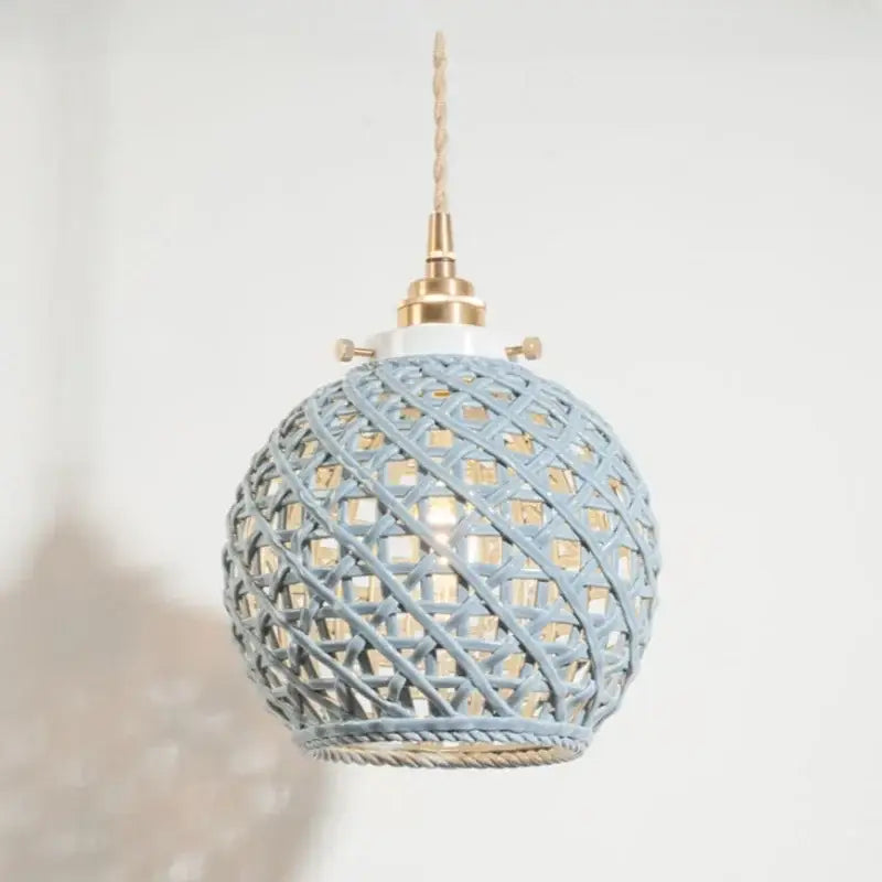 A spherical pendant light with pale blue woven rattan shade and brass accents for decorbites french minimalism ceramic style