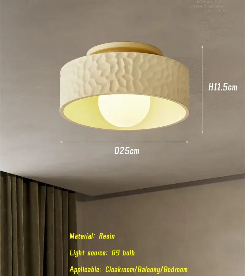 Cream-colored resin ceiling light with textured hammered finish and warm glow for decorbites french minimalist cream decor