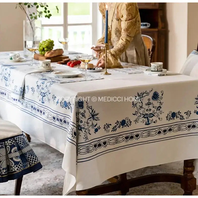 White tablecloth with intricate blue onion print embroidery along edges featuring decorbites blue onion design