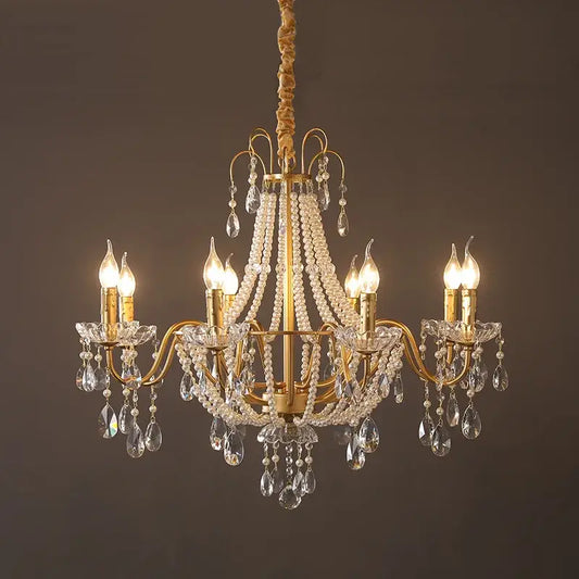 Gold-toned decorbites french pearl chandelier with six lit candle-style bulbs and crystal droplets for living room pendant lighting