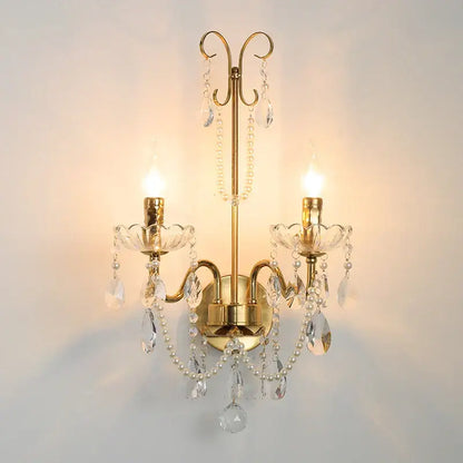 Gold-toned decorbites french pearl wall sconce with candle-style lights, crystal droplets, and white pearl strands for elegant decor