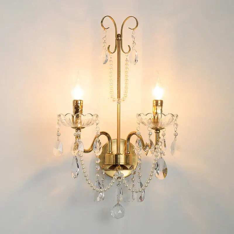 Gold-toned decorbites french pearl wall sconce with candle-style lights, crystal droplets, and white pearl strands for elegant decor