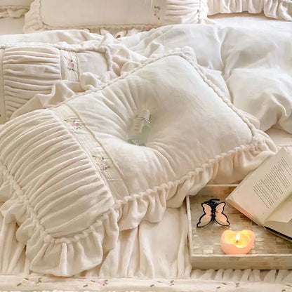 Cream-colored plush pillow with ruffled edges and floral embroidery from decorbites french pleat lace duvet cover set