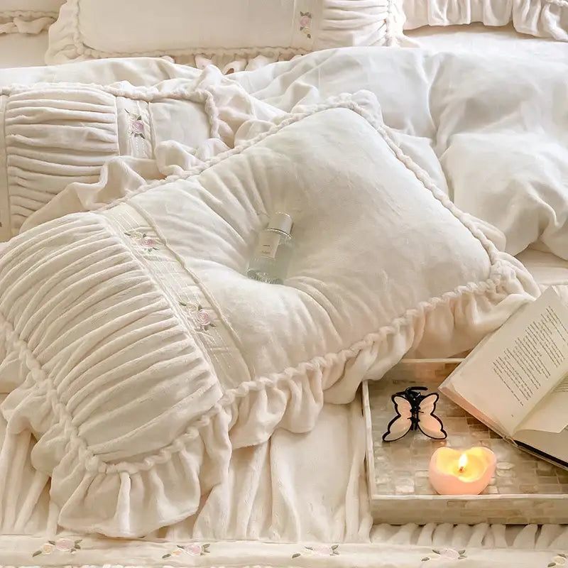 Cream-colored plush pillow with ruffled edges and floral embroidery from decorbites french pleat lace duvet cover set