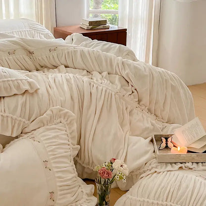 Cream-colored plush velvet duvet cover with ruffled edges and floral embroidery in decorbites french pleat lace style