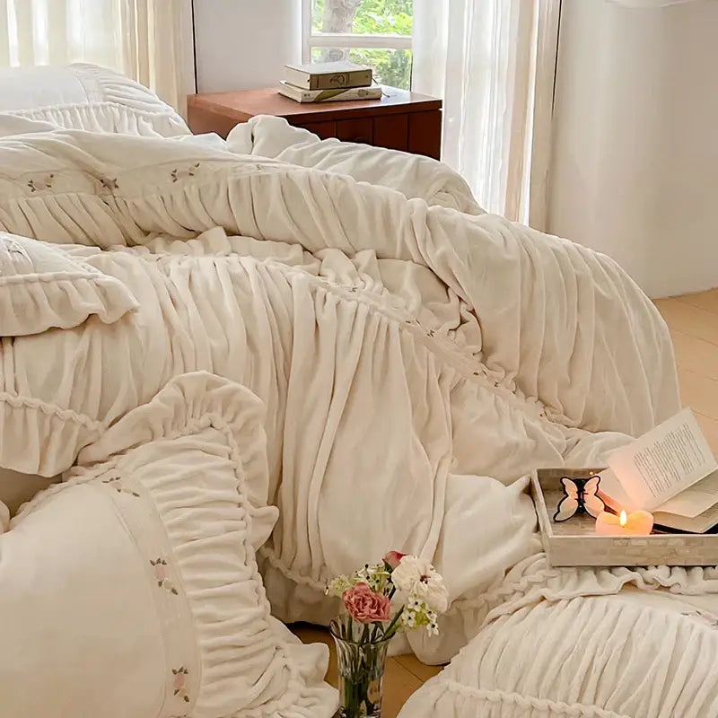 Cream-colored plush velvet duvet cover with ruffled edges and floral embroidery in decorbites french pleat lace style