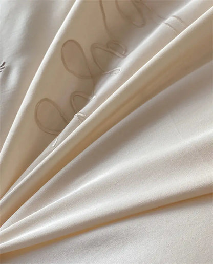 Cream-colored satin fabric with beige embroidered script patterns in decorbites french princess 1000tc bedding set