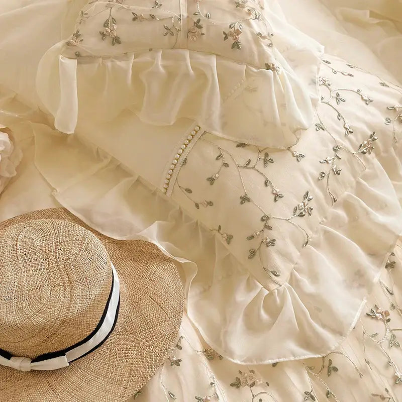 A delicate cream-colored bedding set with silver floral embroidery and layered ruffles decorbites french princess floral