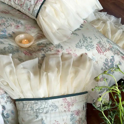 Cream-colored french princess bedding set featuring lace ruffles with floral and architectural print and dark green piping