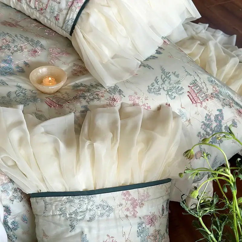 Cream-colored french princess bedding set featuring lace ruffles with floral and architectural print and dark green piping