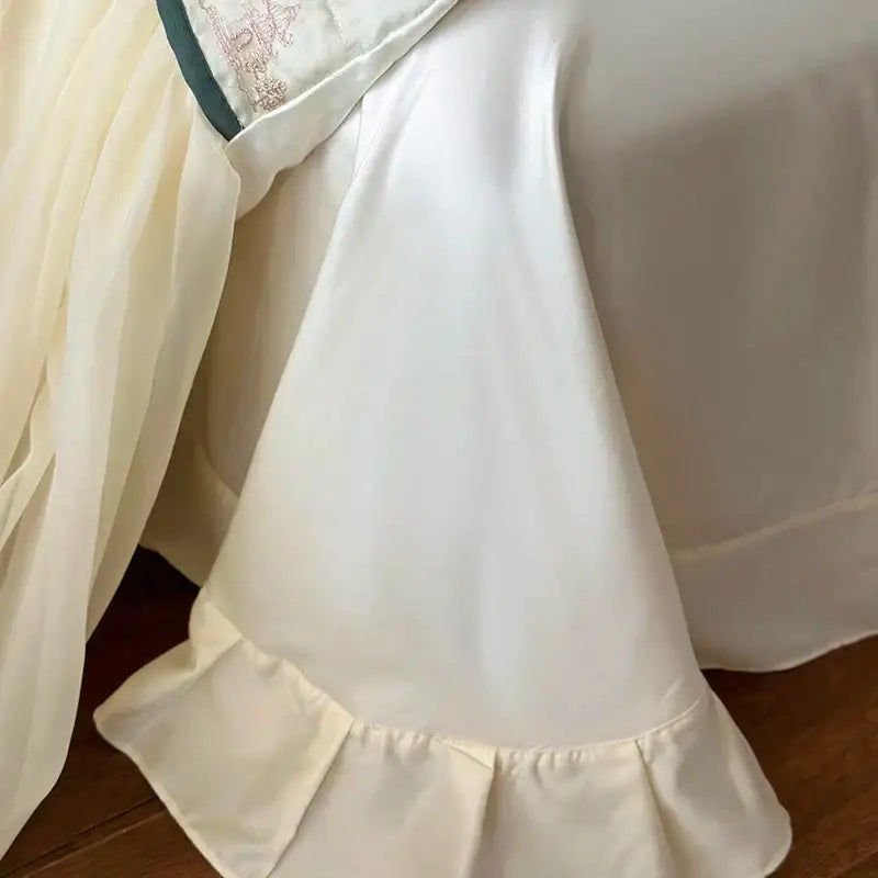 Cream-colored satin bed skirt with lace ruffles and delicate embroidery for french princess bedding set