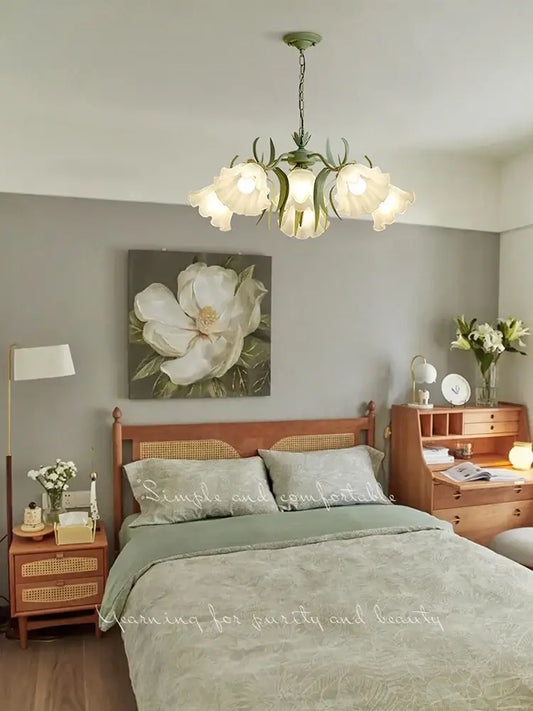 A delicate green metal french retro led flower chandelier with five frosted glass shades hanging from a chain
