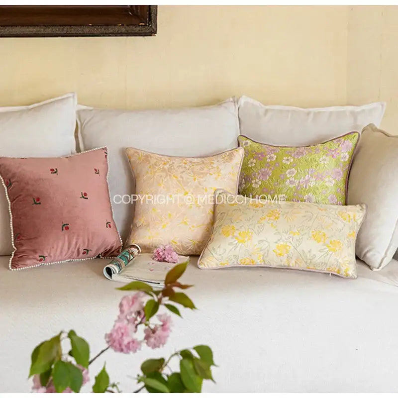 A collection of decorbites contessa camellia throw pillows in soft pastel hues with embroidered floral patterns and lace trim
