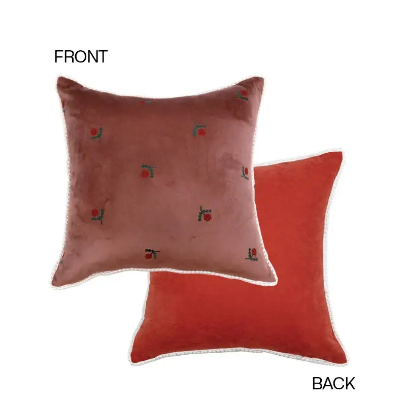 A plush dusty rose velvet decorbites contessa camellia throw pillow with embroidered cherry motifs and white fringe trim