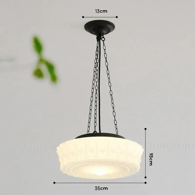A french retro shanghai style dining room pendant light with a cream textured frosted glass shade and black metal chains
