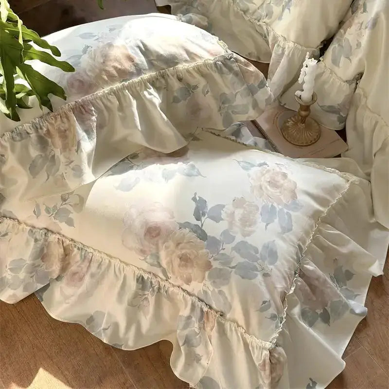 Cream-colored bedding set pillowcases with ruffled edges and muted blush french rose flowers for decorbites french rose