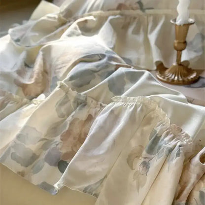 A delicate off-white bedding set with french rose flowers and soft ruffled layers perfect for decorbites decor
