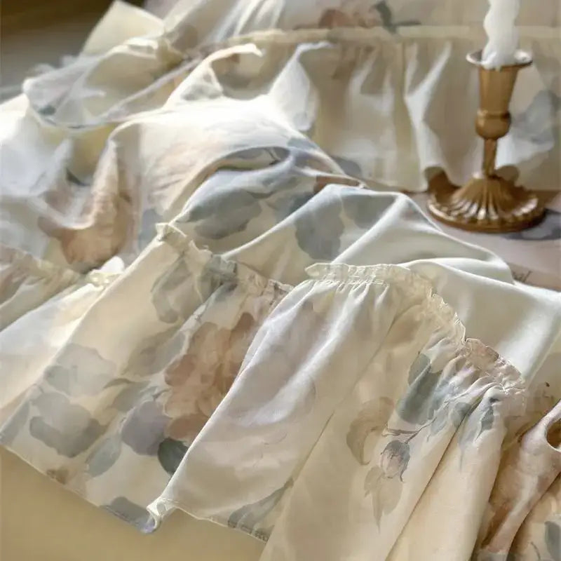 A delicate off-white bedding set with french rose flowers and soft ruffled layers perfect for decorbites decor