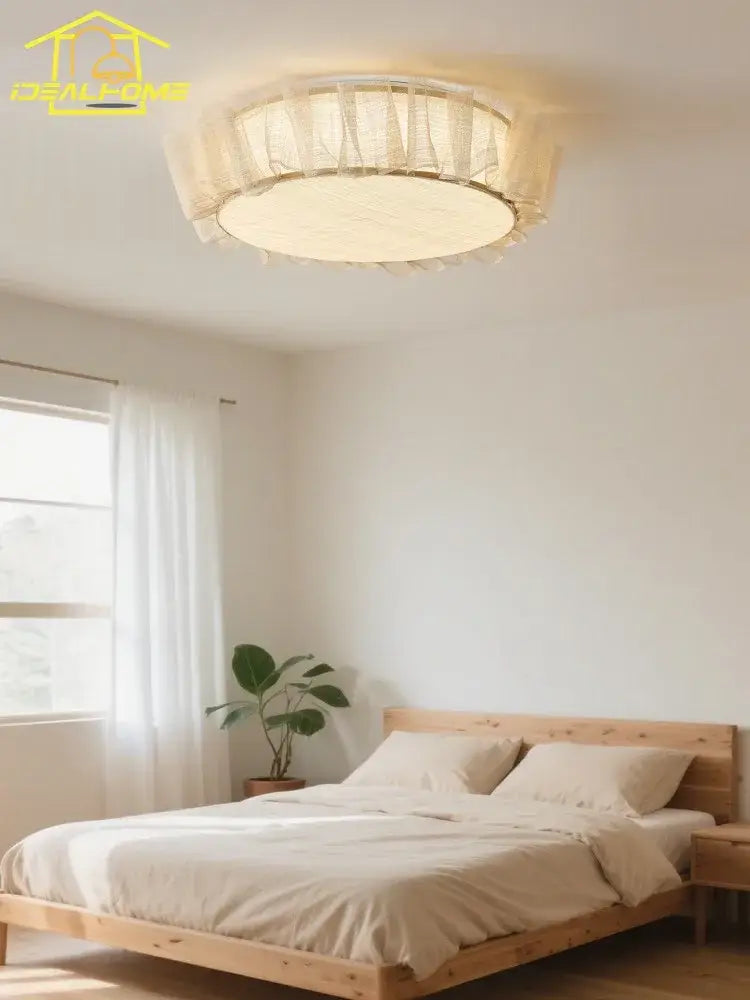 Cream-colored circular ceiling light with sheer ruffled fabric shade and warm glow decorbites cream wind led for bedroom