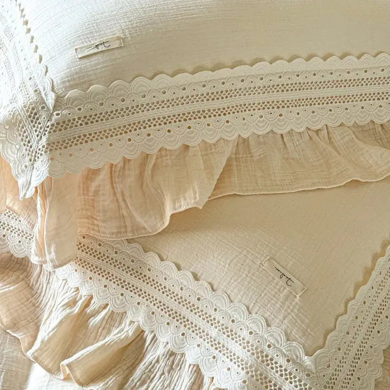 Cream-colored muslin pillowcases with delicate white lace trim and ruffled edges from decorbites french ruffles cotton bedding set