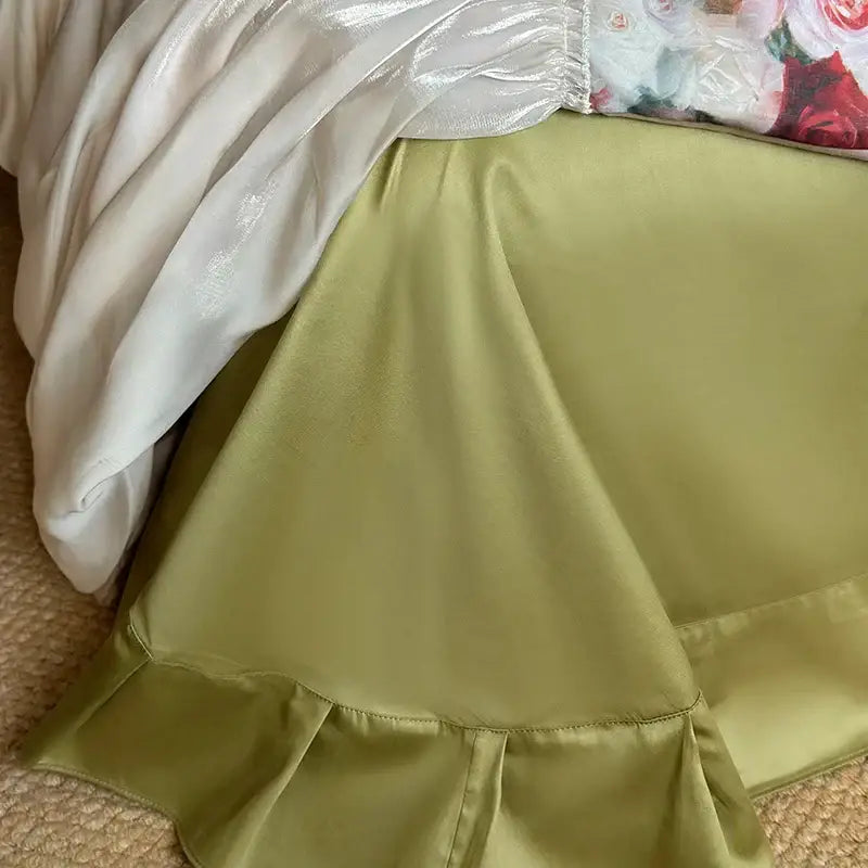 A soft olive green satin skirt with ruffled hem and sheen styled alongside a decorbites french rustic rose cream cotton duvet set