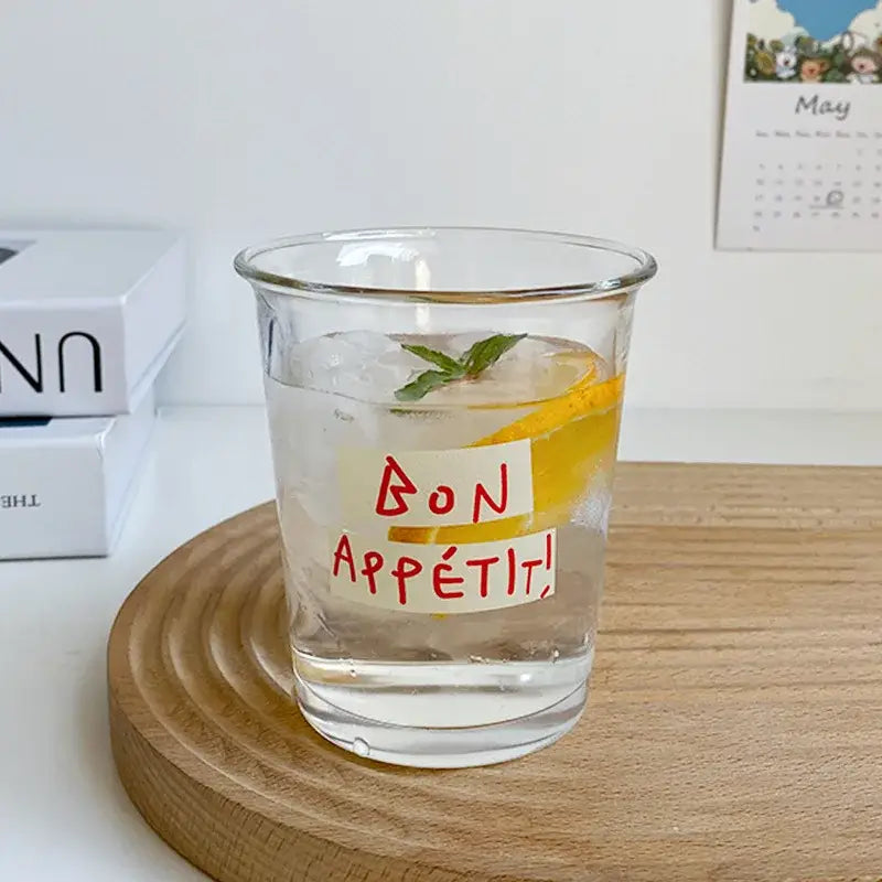 Clear glass tumbler cup with bon appétit sticker filled with ice lemon and mint ideal for kitchen juice use